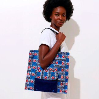 Uma modelo a olhar para a cámara com o saco dobrável em tecido africano azul